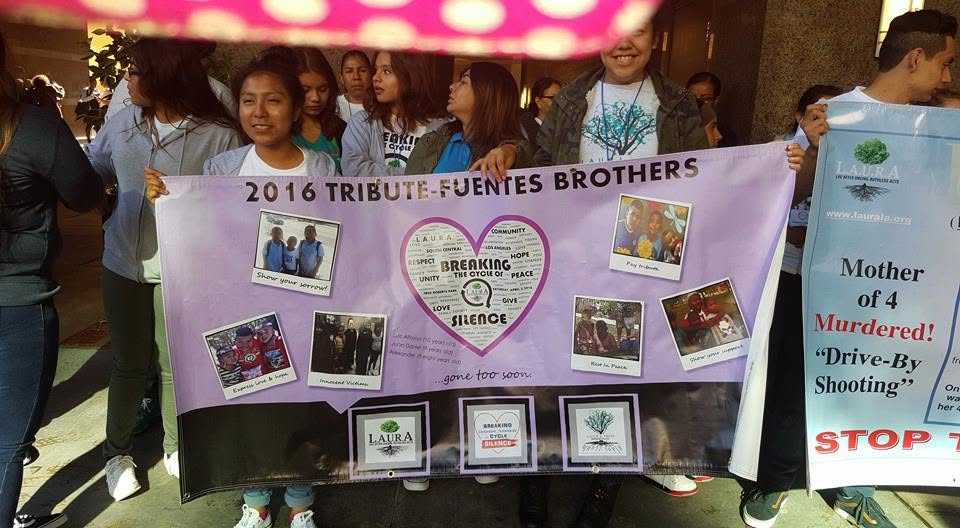 A 2016 tribute banner to the Fuentes Brothers, featuring youth photographs and messages of remembrance